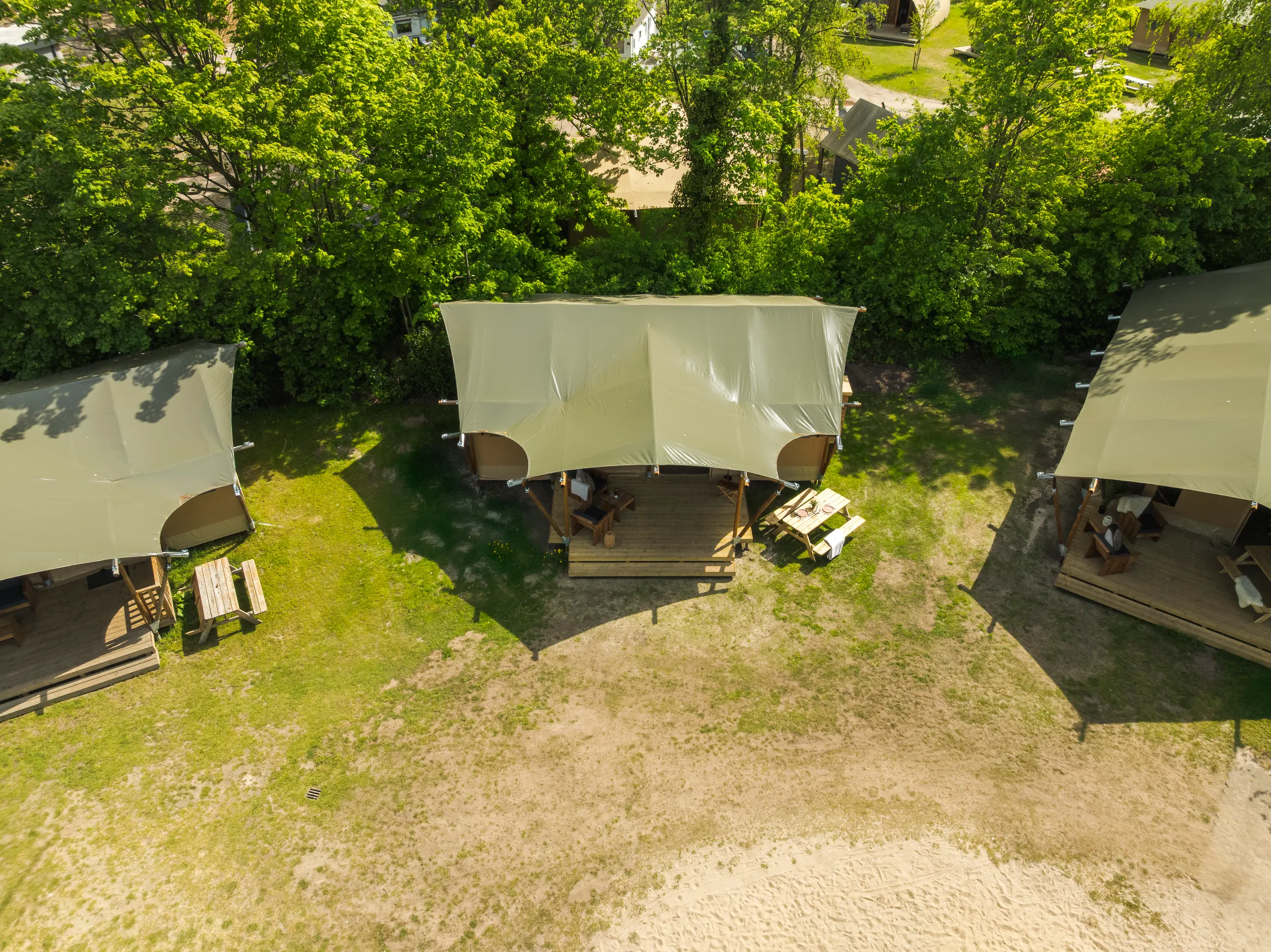 Luxury Safari Lodge: vista aérea de tres tiendas sobre el pasto