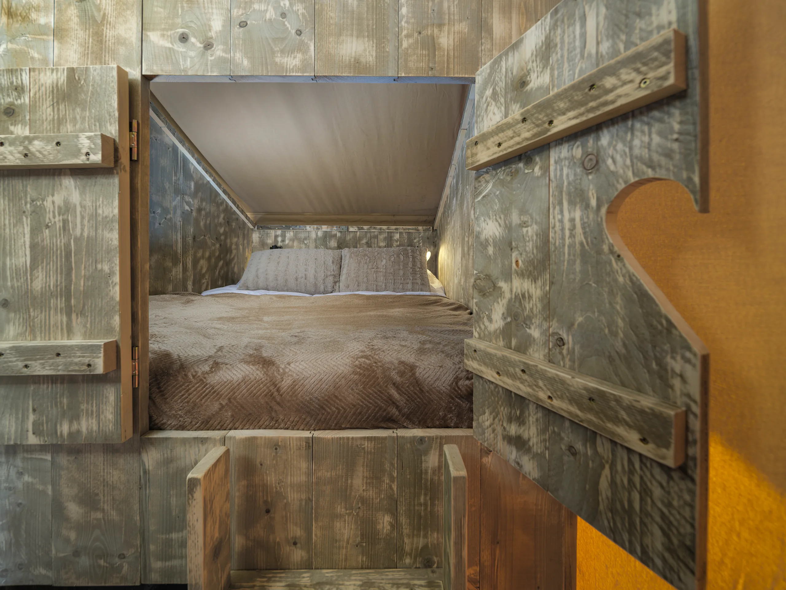 Wood Lodge: cama vista entre puertas de madera