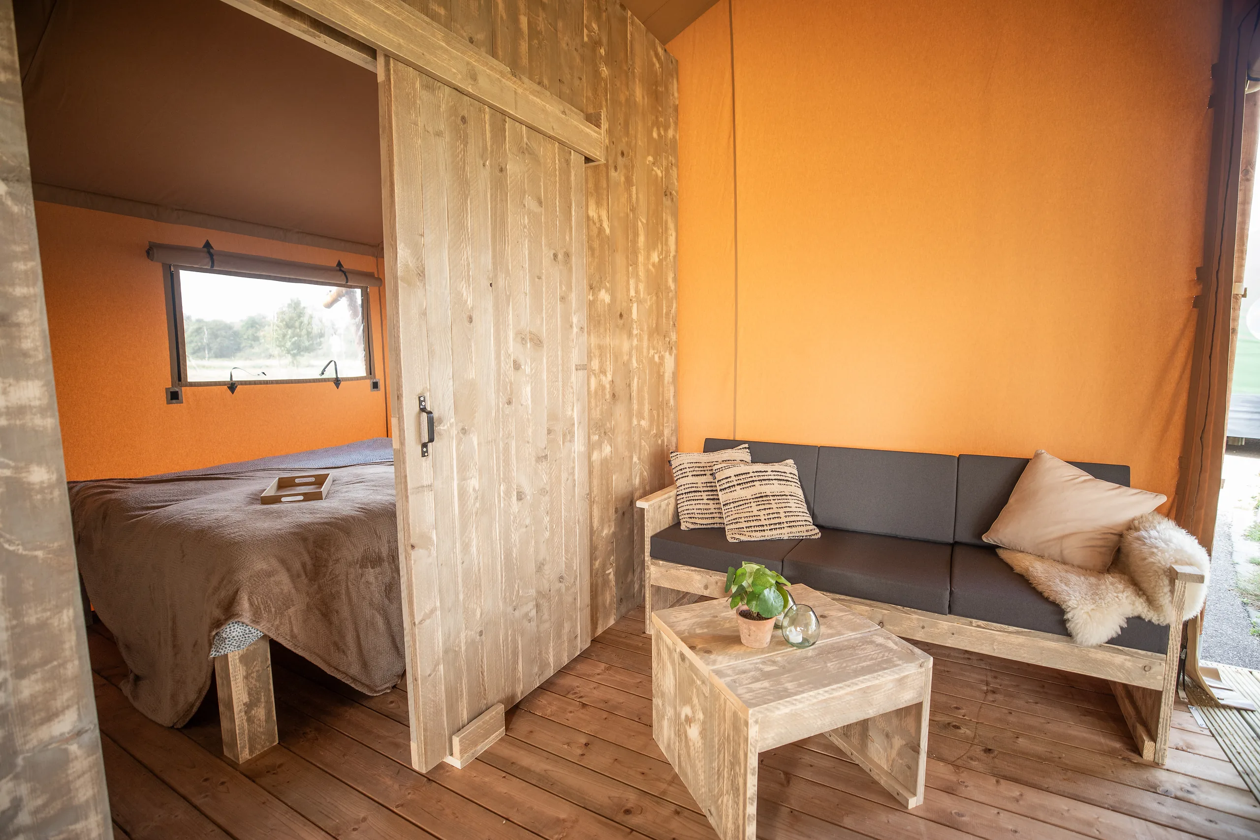 Glamping Lodge 35: recámara con cama matrimonial y la sala al lado
