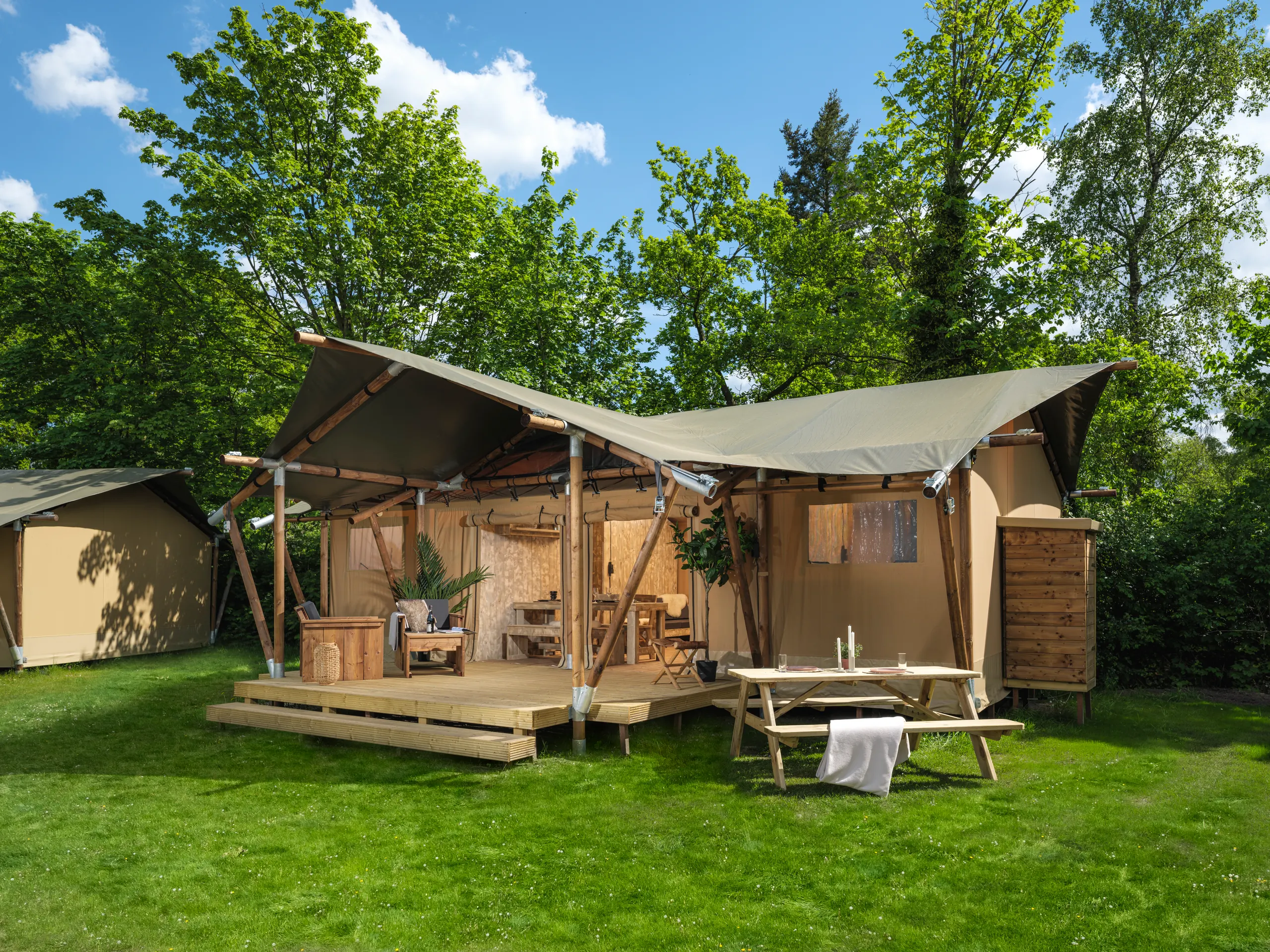 Luxury Safari Lodge: tienda de glamping sobre pasto, con terraza de madera y mesa de picnic al frente
